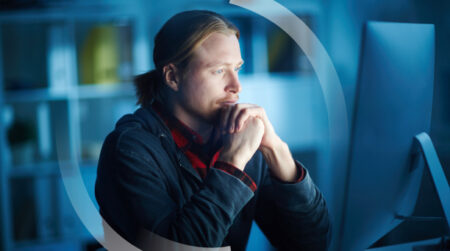 Man looking at a computer screen as he is sat down